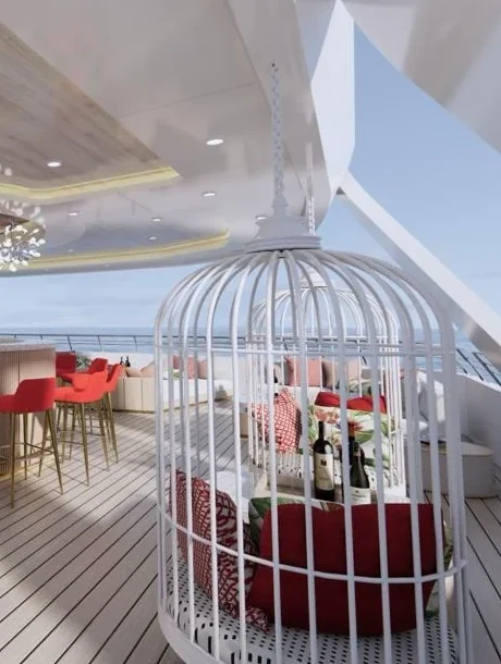 A white birdcage chair with burgundy cushions on the sun deck