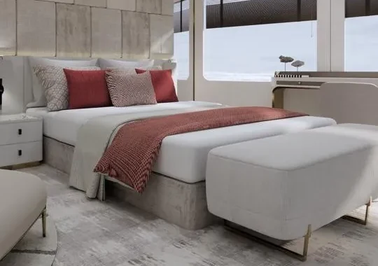 The master bed with a burgundy throw and cushions