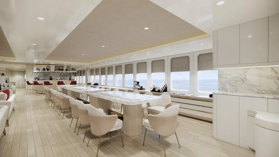 Indoor dining: marble tables and cream chairs along a row of windows